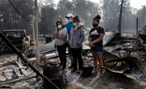 ▲ 10일(현지시간) 미 오리건주 피닉스의 이동 주택 단지에서 한 가족이 산불로 소실된 자신들의 집을 바라보며 슬퍼하고 있다. 사진제공=뉴시스