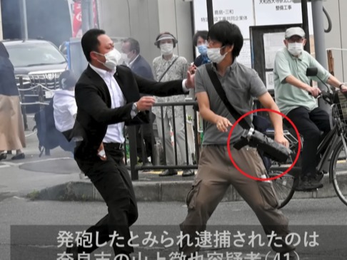▲ 8일 나라시에서 아베 신조 전 일본 총리를 총격한 용의자 야마가미 테츠야가 보안 요원에 의해 제지받고 있다. 용의자가 사용한 총기(적색원)는 3D프린터로 제작됐다는 의견이 나온다. 사진=아사히신문