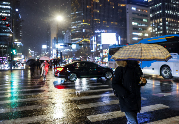 ▲ 눈이 내린 5일 서울 종로구 광화문사거리에서 우산을 쓴 시민들이 이동하고 있다. 2024.02.05. 사진=뉴시스