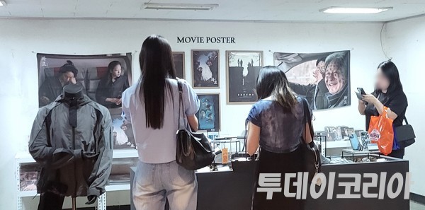 ▲ 관람객들이 ‘파묘: 그곳의 뒤편’ 굿즈판매 공간에서 굿즈를 살펴보고 있다. 사진=투데이코리아