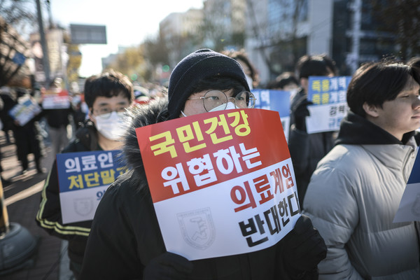 ▲ 지난 8일 서울 종로구 대학로에서 열린 서울대병원 전공의협의회 비상대책위원회 ‘젊은 의사 의료계엄 규탄 집회’에서 사직 전공의를 비롯한 젊은 의사들이 피켓을 들고 있다. 사진=뉴시스