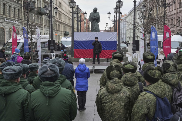 ▲ 18일(현지 시간) 러시아 상트페테르부르크에서 크림반도 합병 11주년을 기념하는 콘서트가 열려 한 경찰관이 노래하고 있다. 뒤에는 우크라이나 출신 19세기 러시아 작가 니콜라 바실료비치 호홀(니콜라이 고골) 동상이 보인다. 사진=뉴시스