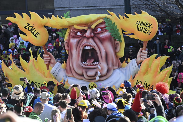 ▲ 지난달 3일 독일 뒤셀도르프에서 열린 전통적 로즈 카니발 퍼레이드에 불꽃에 둘러싸인 도널드 트럼프 미 대통령을 묘사한 카니발 수레 주변에 '병합, 관세, 기후 파괴, 대량 추방'이라는 문구가 쓰여 있다. 사진=뉴시스