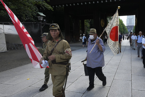 ▲ 제2차 세계대전 패전 79주년을 맞은 지난해 8월 15일 일본 도쿄에서 구식 군복을 입은 사람들이 욱일기를 들고 태평양전쟁 A급 전범이 합사된 야스쿠니신사에 참배하기 위해 본당으로 걸어가고 있다. 사진=뉴시스