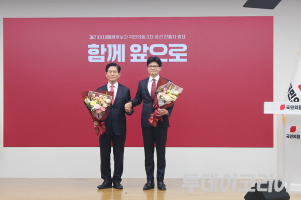 ▲ 국민의힘 대선 최종 경선에 진출한 김문수·한동훈 후보(이름순)가 29일 서울 여의도 당사에서 2차 경선 결과 발표 후 꽃다발을 들고 기념촬영을 하고 있다. 사진=이기봉 기자