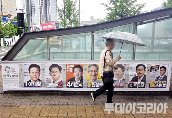 ▲ 16일 서울 시내에 한 시민이 대선후보 선거벽보 앞을 지나가고 있다. 사진=투데이코리아