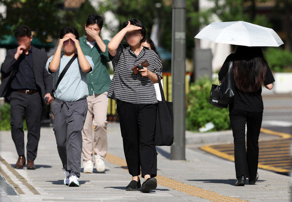 ▲ 서울 종로구 거리에서 시민이 손으로 햇볕을 피하며 이동하고 있다. 사진=뉴시스