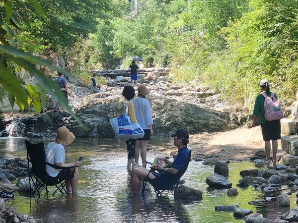 ▲ 경기 양주시 소재 송추계곡을 찾은 시민들이 계곡에 발을 담그고 더위를 식히고 있다. 사진=뉴시스