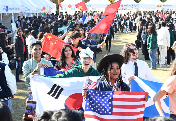 ▲ 경기도 수원시 아주대학교에서 열린 ‘아주 인터네셔널 데이’에서 외국인 유학생들이 각국의 국기와 전통의상을 입고 퍼레이드를 하고 있다. 사진=뉴시스