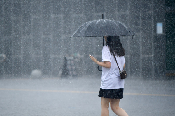 ▲ 광주 동구 국립아시아문화전당 주변에 내리는 소낙성 폭우 속에서 한 시민이 길을 재촉하고 있다. 사진=뉴시스