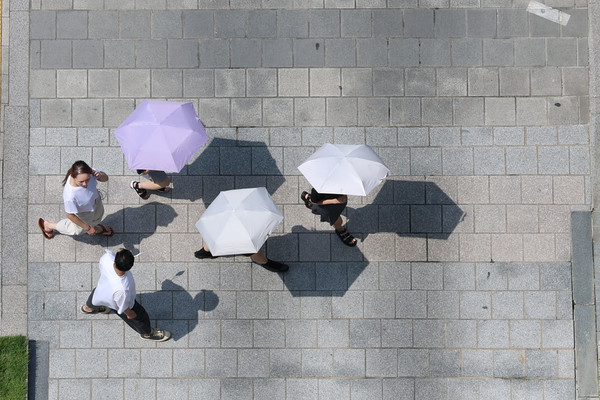 ▲ 서울 중구 프레스센터 인근에서 시민들이 양산을 쓰고 이동하고 있다. 사진=뉴시스