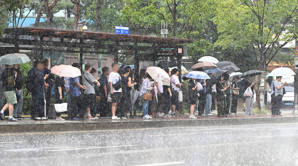 ▲ 경기 수원시 망포역 인근 버스정류장에서 출근길 시민들이 우산을 쓴 채 버스를 기다리고 있다. 사진=뉴시스