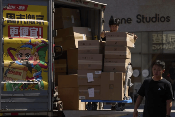 ▲ 지난 1일 중국 베이징의 인기 야외 쇼핑몰 밖에서 한 근로자가 트럭에서 상품 상자를 싣고 있다. 사진=뉴시스