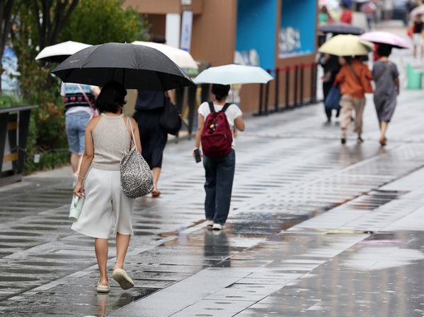 ▲ 서울 종로구 광화문광장에서 우산을 쓴 시민들이 발걸음을 옮기고 있다. 사진=뉴시스