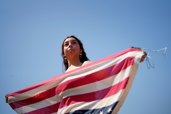 ▲ 미 캘리포니아주 로스앤젤레스(LA) 도심에서 한 여성이 미국 국기를 거꾸로 들고 시위하고 있다. 사진=뉴시스