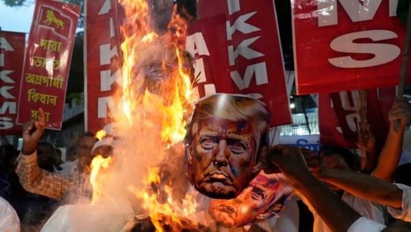 ▲ 8월13일(현지시간) 인도 콜카타에서 열린 무역 관세와 가자 전쟁에 반대하는 시위에서 다양한 노동조합과 농민 단체의 활동가들이 미국 영사관 근처에서 도널드 트럼프 미국 대통령의 초상화를 불태우고 있다. 사진=뉴시스