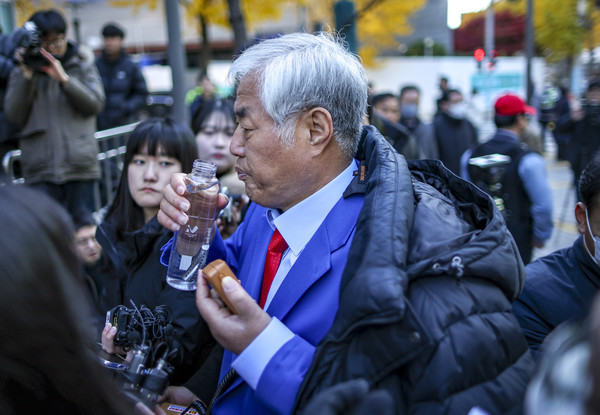 ▲ 특수건조물침입·특수공무집행방해 교사 등 혐의를 받는 전광훈 사랑제일교회 목사가 18일 서울 종로구 서울경찰청으로 피의자 신분 조사를 받기 위해 출석하며 입장을 밝히며 물을 마시고 있다. 사진=뉴시스