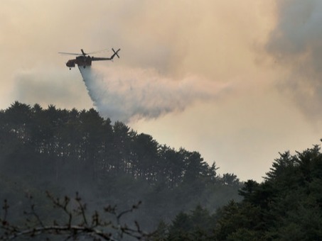 ▲ 사흘째 이어지고 있는 울진·삼척 산불을 막기 위해 공중 진화 작업 중인 헬기.