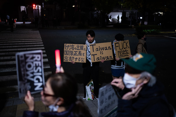 ▲ 21일 밤 일본 도쿄 총리실 앞에서 시위대가 다카이치 사나에 총리의 대만 관련 발언에 반대하며 시위하는 가운데 한 남성이 대만을 지지하는 손팻말을 들고 있다. 사진=뉴시스